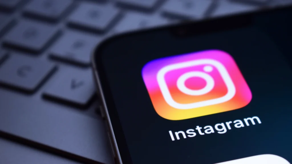 Close-up of the Instagram app icon on a mobile phone, representing new Instagram Insights metrics, API updates and improved content management tools for Instagram marketing.