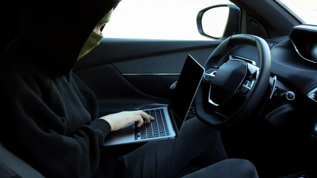 Person using a laptop inside a car, illustrating keyword hijacking and malicious online activity.