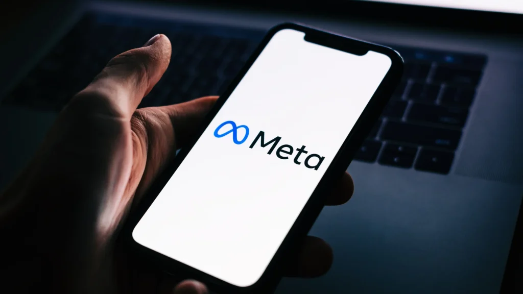 Smartphone displaying the Meta logo, representing updates to Meta Ads attribution transparency and AI-driven conversion reporting for social media advertising