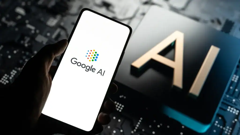 Close-up photo of a smartphone displaying the Google AI logo next to a large metallic “AI” symbol, representing the future of artificial intelligence technology driving digital marketing and SEO innovation.