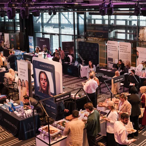 Exhibitor stands and attendees during a lunch break at Aesthetic Business Masters Sydney